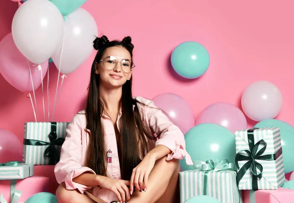 Close-up portrait of attractive girl with present and balloons for studio.