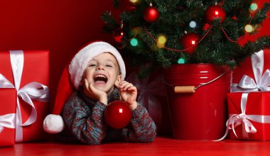 Mutlu Noel ve yeni yıl. Noel hediyeleri için bekleyen Santa kırmızı şapkalı çocuk portresi. 
