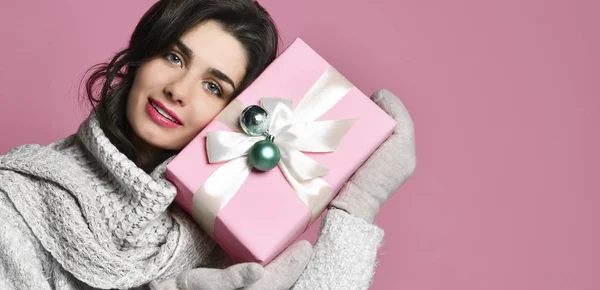 Retrato de mulher jovem segurar presente. Sorrindo menina feliz no fundo rosa . — Fotografia de Stock