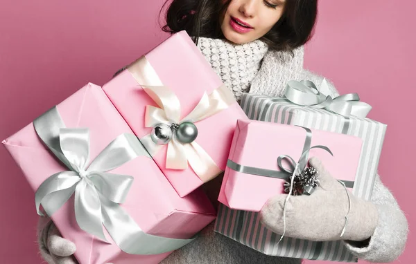 Vrolijke vrouw met een heleboel dozen met geschenken op een roze achtergrond. — Stockfoto