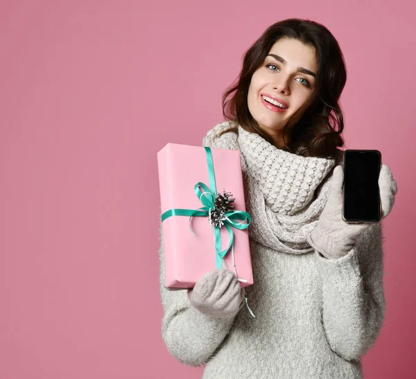 Vrouw is houden van vakken en tonen leeg scherm mobiele telefoon geïsoleerd op roze achtergrond — Stockfoto
