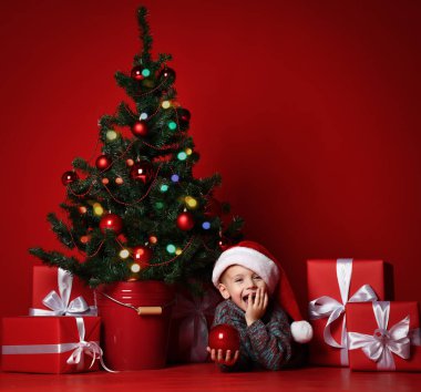 Mutlu Noel ve yeni yıl. Noel hediyeleri için bekleyen Santa kırmızı şapkalı çocuk portresi. 