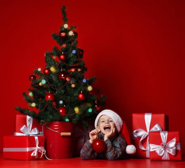 Mutlu Noel ve yeni yıl. Noel hediyeleri için bekleyen Santa kırmızı şapkalı çocuk portresi. 