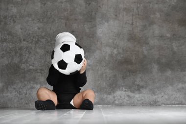 bir futbol topu tutan bebeğin sevimli görüntü.