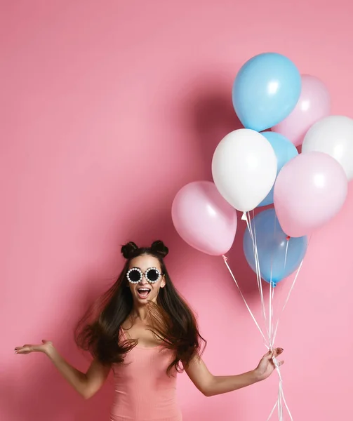 Zbliżenie ładny blond dziewczynę stojącą w studio, uśmiechając się szeroko i grając z baloons niebieski i różowy. — Zdjęcie stockowe