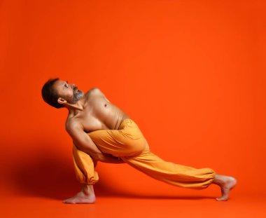 Yoga poz yapan üst düzey sakallı erkek stüdyo çekim