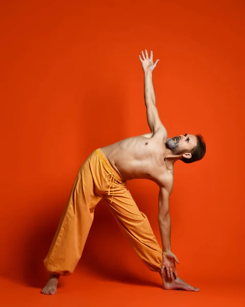 Estudio de tiro de hombre barbudo senior haciendo poses de yoga — Foto de Stock