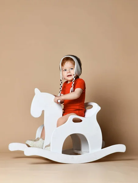 Little smiling baby sitting on a white horse, wooden rocking — Stock Photo, Image