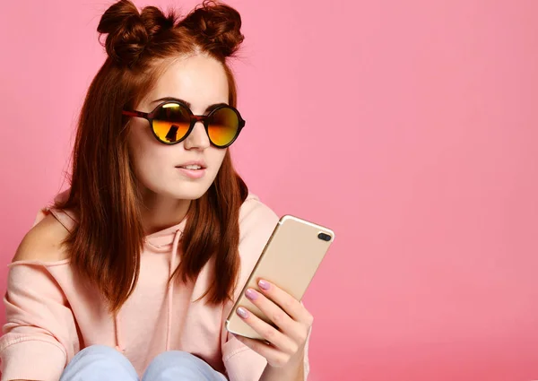 Mujer joven seria en gafas de moda se concentró en la información mirando el teléfono — Foto de Stock