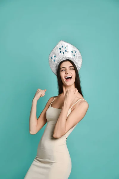 Gambar wanita muda yang gembira di topi kokoshnik berdiri terisolasi di atas latar belakang biru membuat gerakan pemenang . — Stok Foto