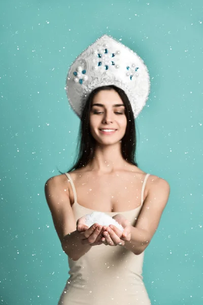 Smiley vrouw houden sneeuw geïsoleerd op blauw — Stockfoto