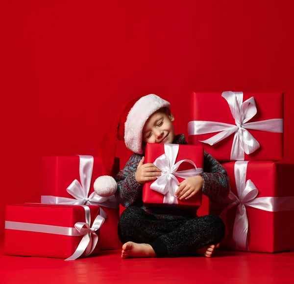 Portrait of thoughtful boy in Santa hat isolated on red background — Stock Photo, Image