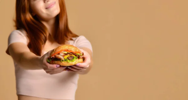 Portre aç genç bir kadının çıplak arka plan üzerinde izole hamburger yeme kapatmak — Stok fotoğraf