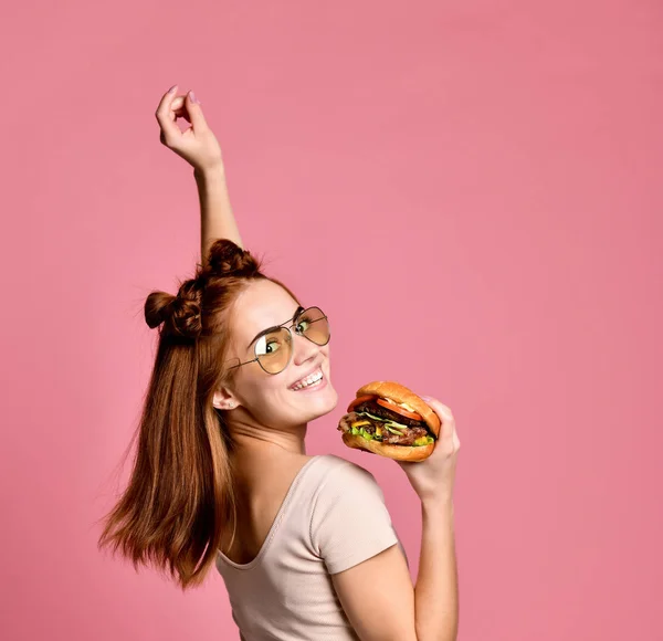 Horisontella studio skott av vackra unga kvinna som håller en hamburgare — Stockfoto