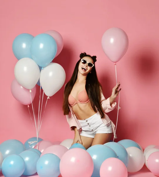 Beautiful fashion Model Party girl with colorful Balloons posing at studio isolated on Pink.