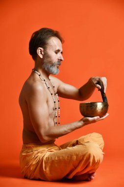 bir gri sakal yogi şarkı kase tutarak fiziksel görünüm olarak iyi olan yaşlı adam