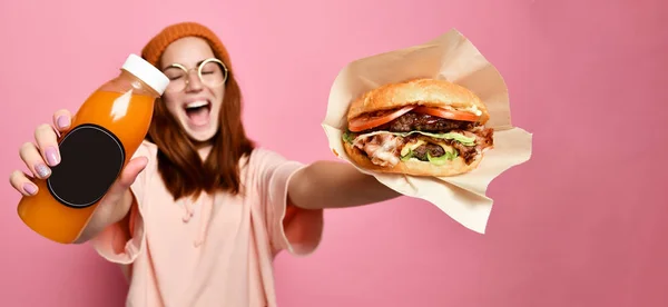 Hamburger ve şişe suyu tutan hipster hoodie bez gülümseyen güzel genç sarışın bir kadın modeli — Stok fotoğraf