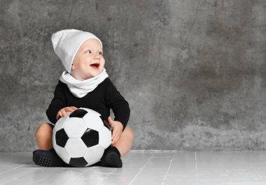 bir futbol topu tutan bebeğin sevimli görüntü.