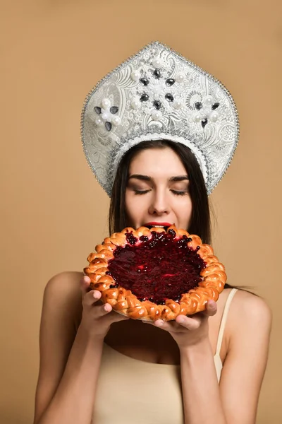 Mujer joven comiendo pastel abierto con un relleno — Foto de Stock