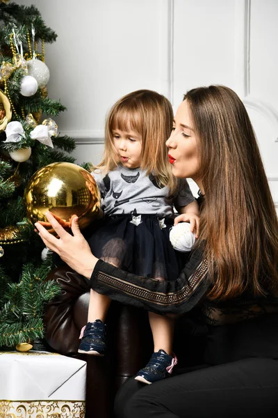 Mãe com sua filha criança celebrando perto da árvore de Natal — Fotografia de Stock