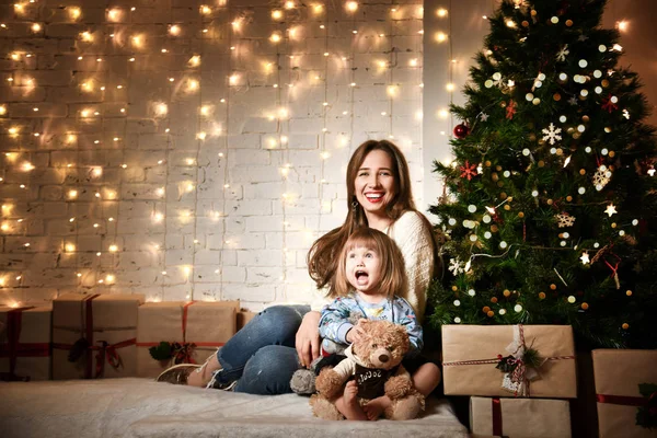 Jovem mãe e suas filhas perto da árvore de Natal . — Fotografia de Stock