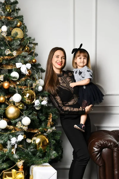 Mãe com sua filha criança celebrando perto da árvore de Natal — Fotografia de Stock