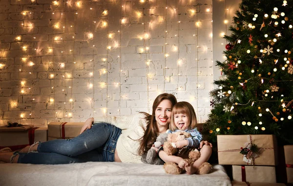 Jovem mãe e suas filhas perto da árvore de Natal . — Fotografia de Stock