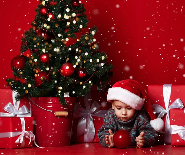 Mutlu küçük gülümseyen çocuk Noel topu ile