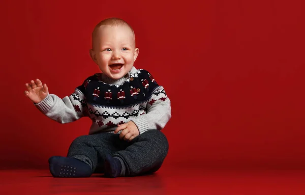 Весела маленька дитина в теплому в'язаному новорічному светрі в студії в холодний зимовий день . — стокове фото
