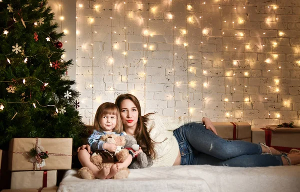 Jovem mãe e suas filhas perto da árvore de Natal . — Fotografia de Stock