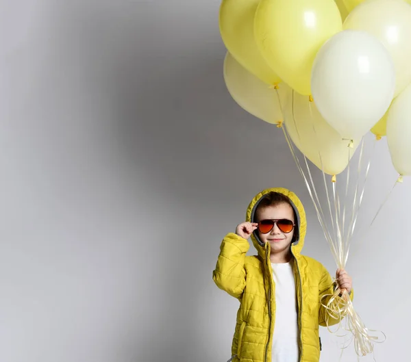 Стильний маленький хлопчик тримає повітряну кулю ізольовано на білому — стокове фото