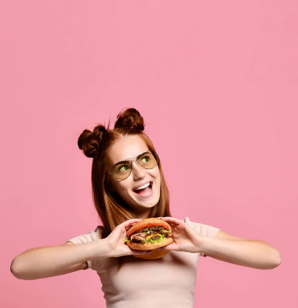 Beyaz arka planda izole edilmiş hamburger yiyen genç bir kadının portresi. — Stok fotoğraf