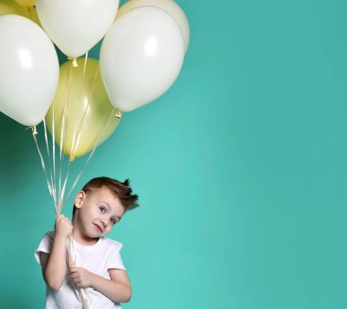 Bir sürü balon tutan tatlı bir çocuk.