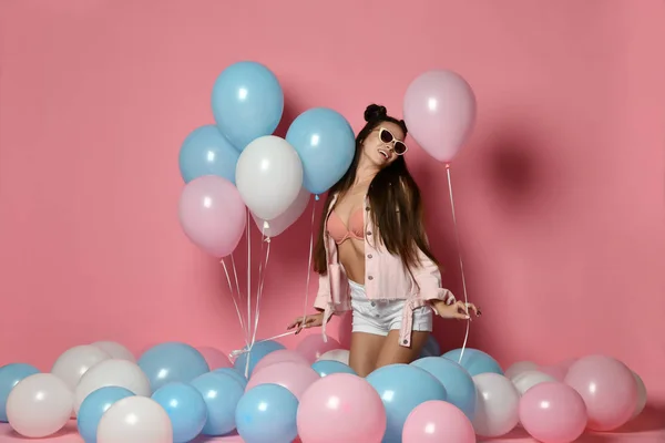 Beautiful fashion Model Party girl with colorful Balloons posing at studio isolated on Pink.