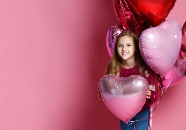 Kalp şeklinde ballon tutan mutlu küçük kız