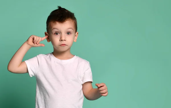 Yeşil arka plan üzerinde kulakları kapsayan çocuk.