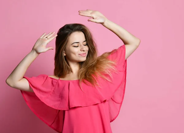 Retrato de morena chica hipster caucásica bailando contra la pared con sonrisa, regocijando buen humor. Estudiante hembra divertirse mientras baila con un poco de música agradable en el interior —  Fotos de Stock