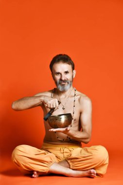 bir gri sakal yogi şarkı kase tutarak fiziksel görünüm olarak iyi olan yaşlı adam