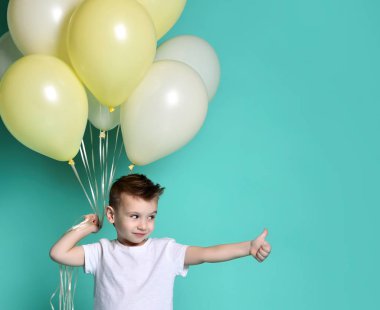 Bir sürü balon tutan tatlı bir çocuk.