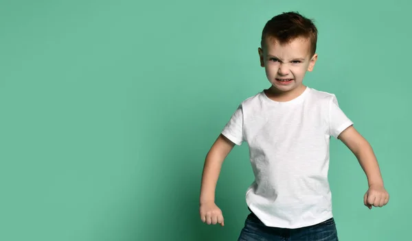 Angry little boy looks straight to camera