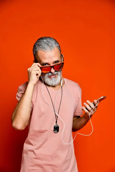 Uma imagem de um idoso ouvindo música com fones de ouvido — Fotografia de Stock