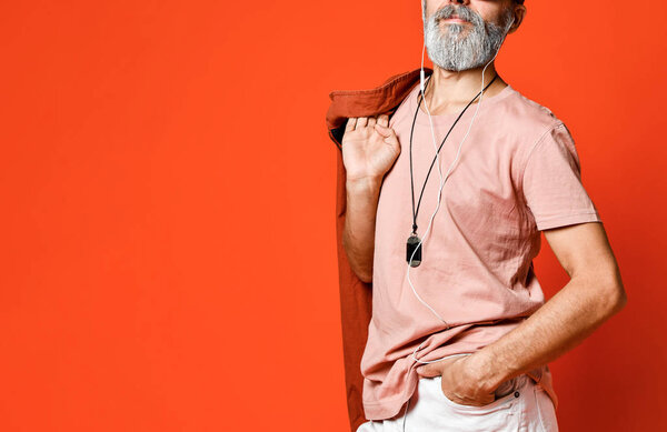 Портрет крутого, мужественного, модного старика, держащегося за руку в кармане, смотрящего на камеру в солнечных очках
