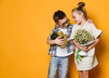 Tam uzunlukta bir hediye kutusu gri duvardan kız arkadaşına veren gülümseyen bir adam portresi