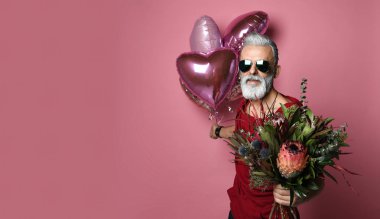 Balonları ve çiçekleri olan orta yaşlı bir adam..