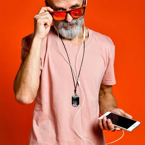 Uma imagem de um idoso ouvindo música com fones de ouvido — Fotografia de Stock