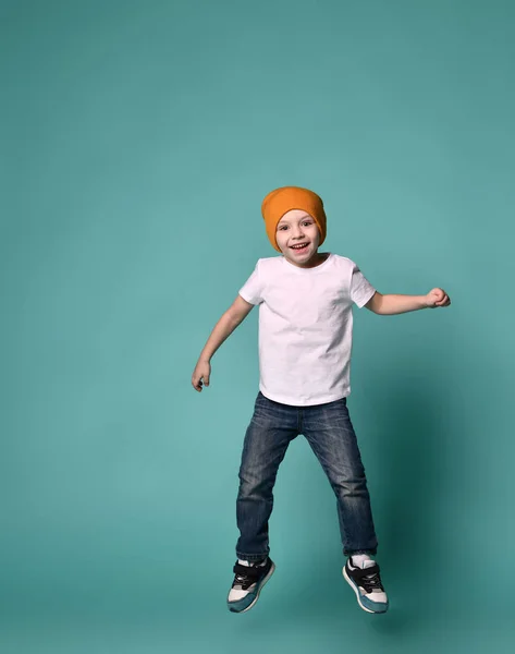 Obraz z mały chłopiec dziecko skoki na białym tle nad zielonym tle. — Zdjęcie stockowe