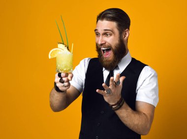 Sakallı sakallı barmen yeleğinde kokteyl tutuyor.