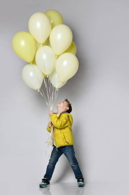 Beyaz balon tutan şık küçük çocuk.