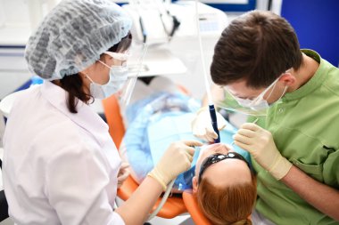 Diş hekimi kadın ağzını temizlemeye başlıyor