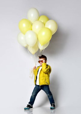 Beyaz balon tutan şık küçük çocuk.